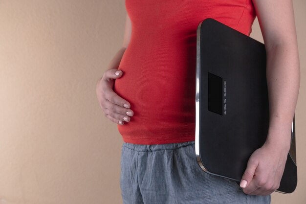 A close-up view of the belly of a pregnant woman in red