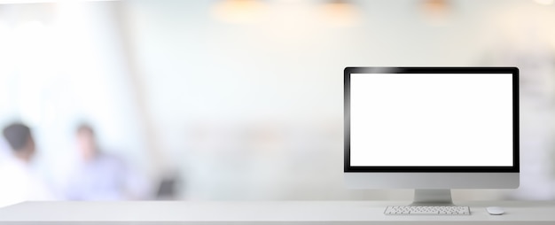 Close up view of blank screen computer and copy space on white table in blurred office room background