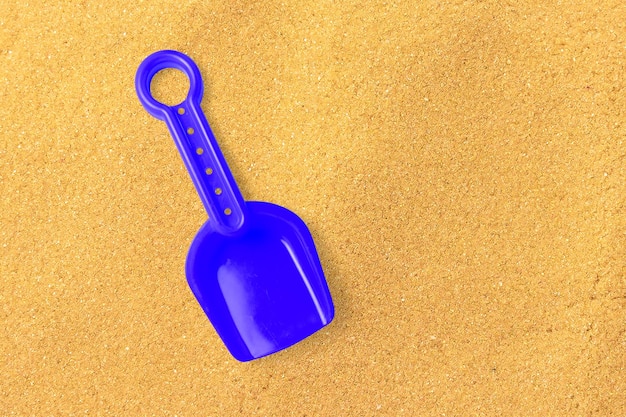 Close up view blue sand shovel isolated on sand beach added copy space for text