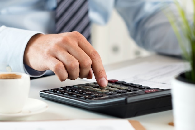 Close up view of bookkeeper or financial inspector hands making report, calculating or checking balance