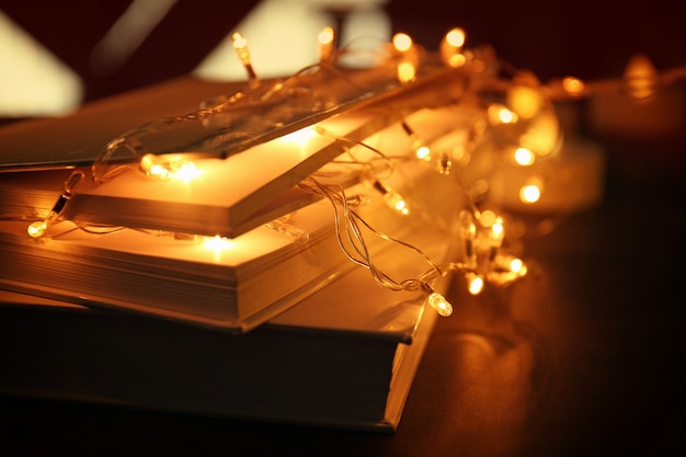 Close up view of books and beautiful garland on table