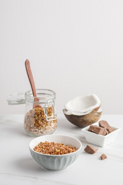 Close-up view of bowl with granola with coconuts and chocolate.