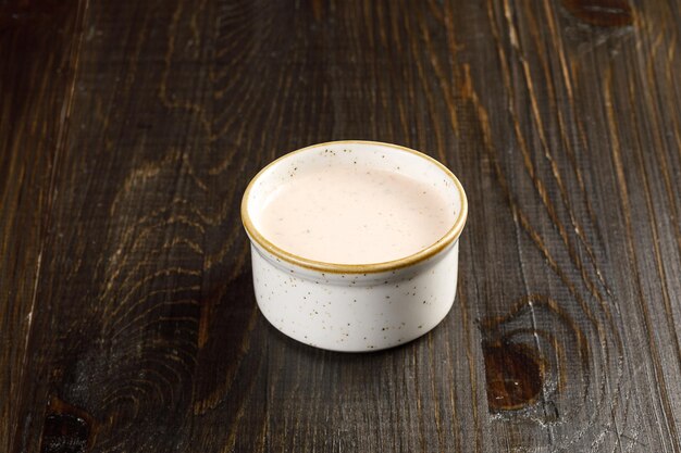 Close up view of bowl with sauce over wooden rustic background