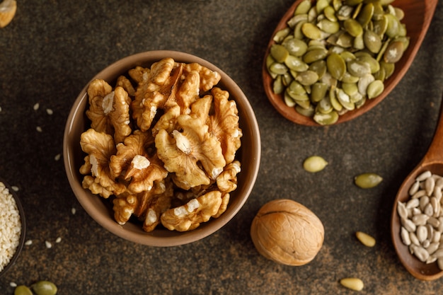 Close-up view of bowl with walnuts over dark table