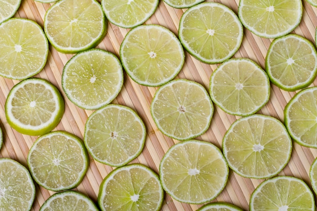 Close up view of a bunch of round slices of lime fruit isolated on a white background.