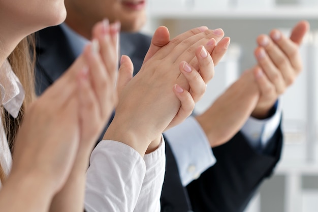 Close up view of business seminar listeners clapping hands. Professional education, business meeting, presentation or coaching concept