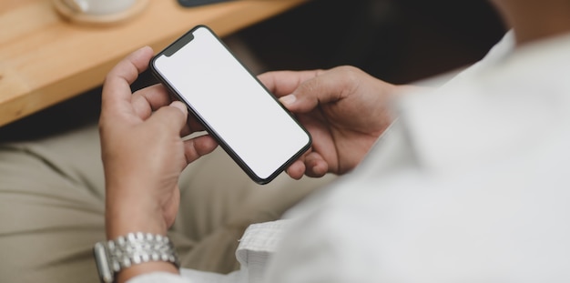 Close-up view of businessman holding blank screen smartphone