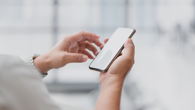 Close up view of  businessman touching  blank screen  with blurred office room