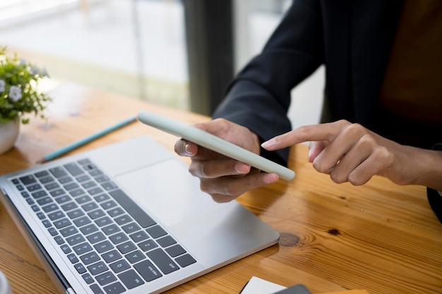 Close up view of businesswoman typing on smart phone while sitting in office