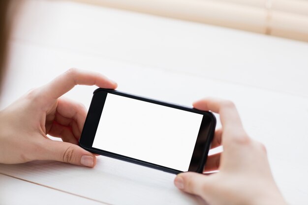 Close up view of businesswoman using her phone at her desk in office