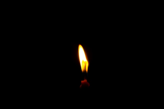 Close up view of Candle light of peace in the dark and yellow flame sue as peace elements yoga