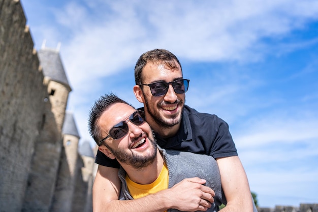 Close up view of a caucasian gay couple embraced next to the walls of a medieval fortification