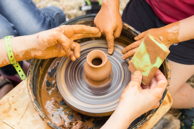 子供と一緒にろくろでの陶磁器の製造プロセスの拡大図子供と一緒に粘土工芸品