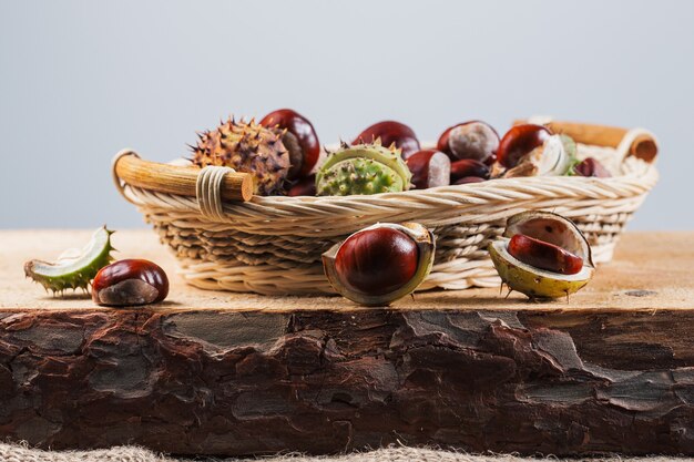 Close up view of Chestnuts in a basket on a wooden background.