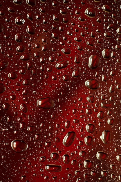 Photo close up view of cold drops on the glass of beer background. texture of cooling alcohol drink with macro bubbles on the glass wall. fizzing or floating up to top of surface. dark brown colored.