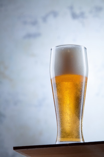 Foto primo piano vista sul freddo bicchiere di birra si trova di fronte a un muro di cemento