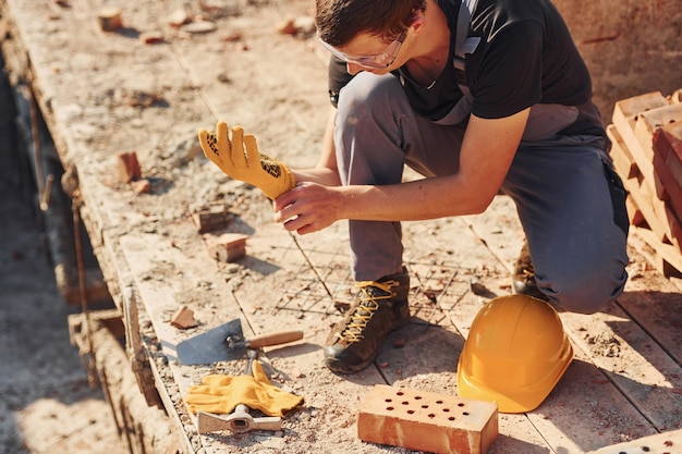 Close up view of construction worker in uniform and safety equipment preparing for the job