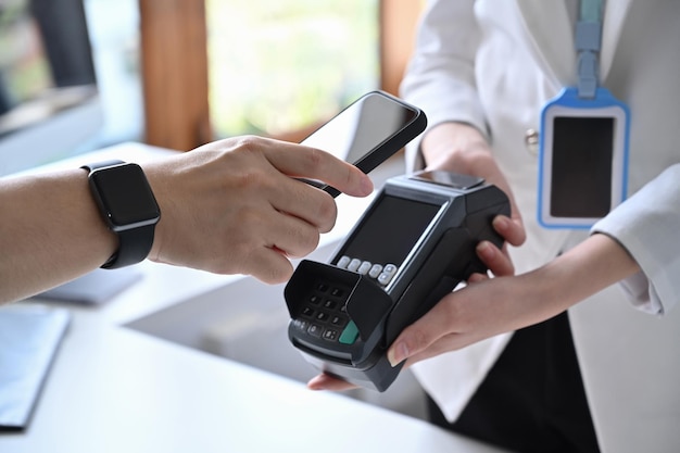 Close up view customer hand holding smartphone and scanning for digital payment.