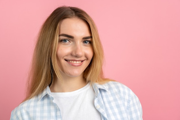 Close up view. Cute, smiling girl on a pink background