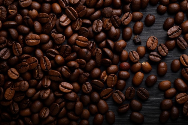 close up view of dark fresh roasted coffee beans on coffee beans background