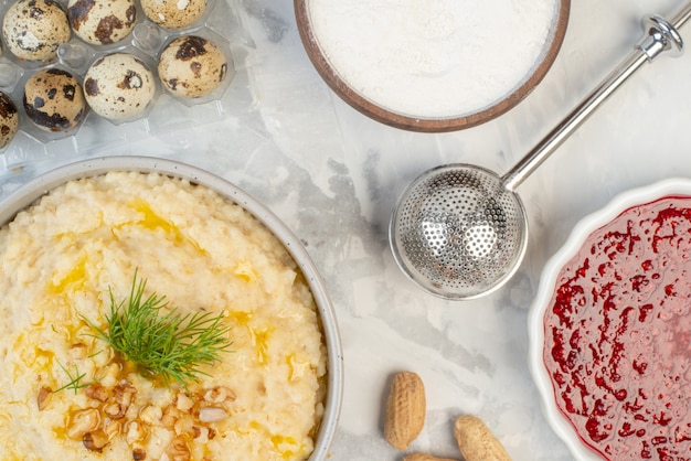 Close up view of delicious breakfast with oats jam flour eggs spikes on ice background