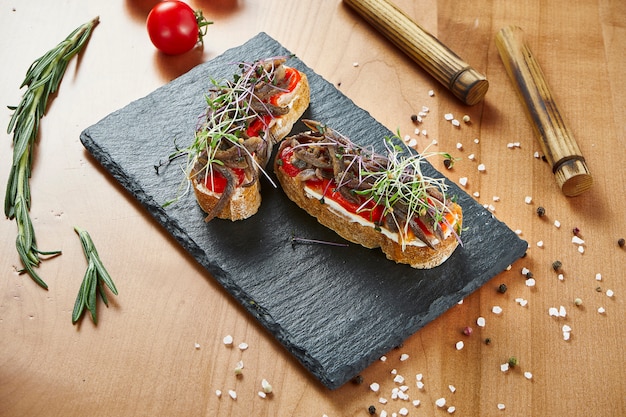 Close up view delicious bruschetta with beef and tomatoes on wooden surface
