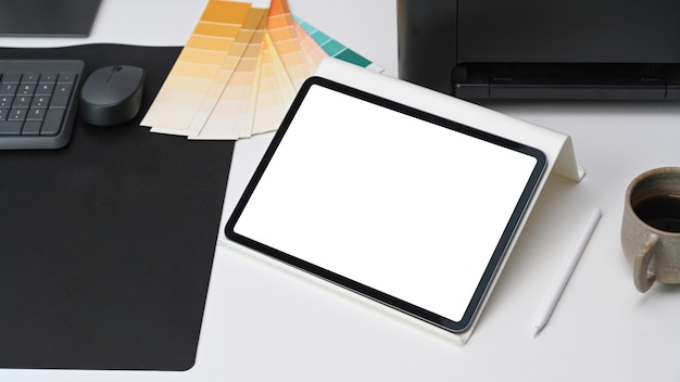 Photo close up view of digital tablet with white screen on graphic designer workspace.