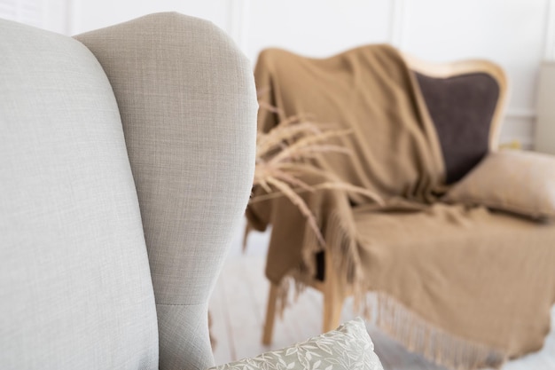 Close up view of elegant and comfort armchair in room with boho style interior. Home interior concept.