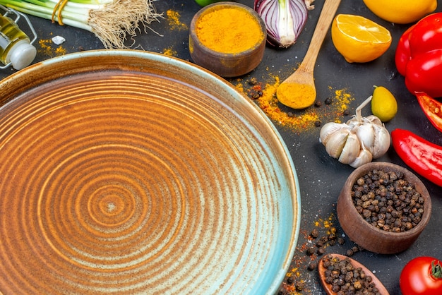 Close up view of empty plate and fresh vegetables spices green bundle on black table