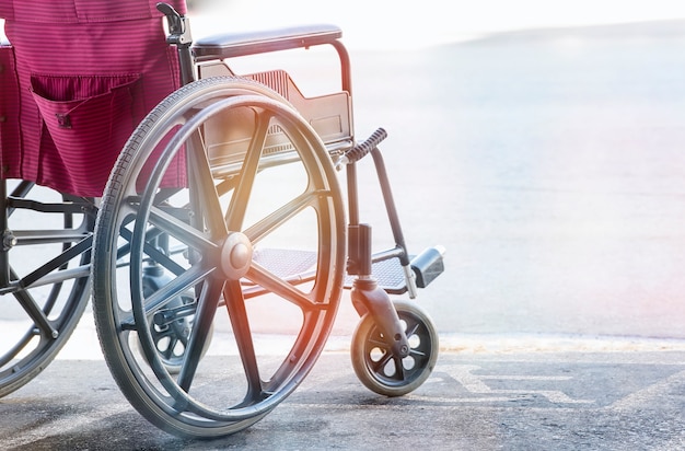 close up view of empty wheelchair with Pavement handicap symbol 