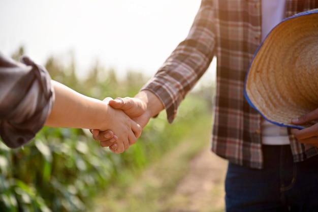 Close up view of farmers checking hands and making a deal with female reaching agreement deal