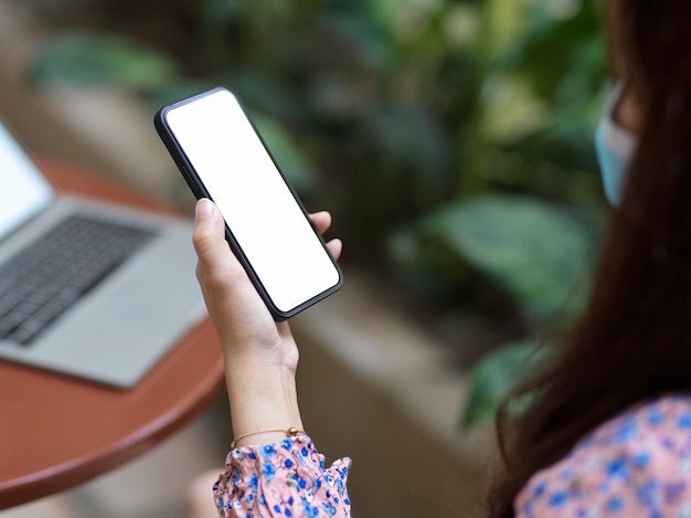 Close up view of female in beautiful spring dress using smartphone