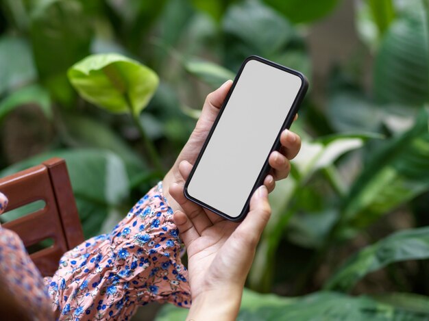 Close up view of female in beautiful spring dress using smartphone