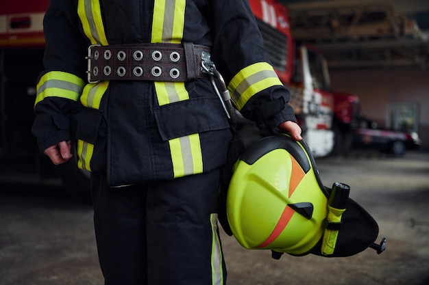 Close up view Female firefighter in protective uniform standing near truck