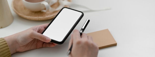 Close up view of female freelancer using mock-up smartphone to contact customer