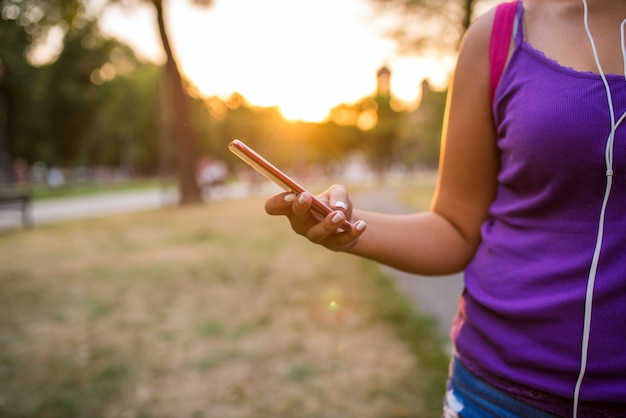 Vista del primo piano dei messaggi mandanti un sms femminili nel parco