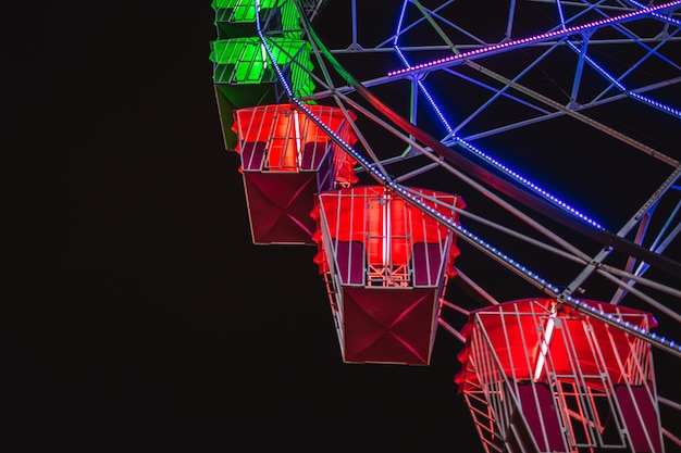 Photo close-up view ferris wheel at night. part of ferris wheel against a dark sky with lights night lighting. festive concept.