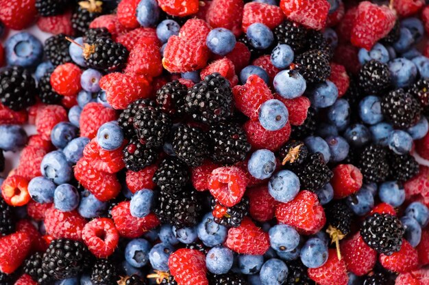 Close up view of fresh ripe mixed Blueberries blackberries and raspberries as flatlay background