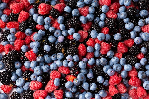 Close up view of fresh ripe mixed Blueberries blackberries and raspberries as flatlay background