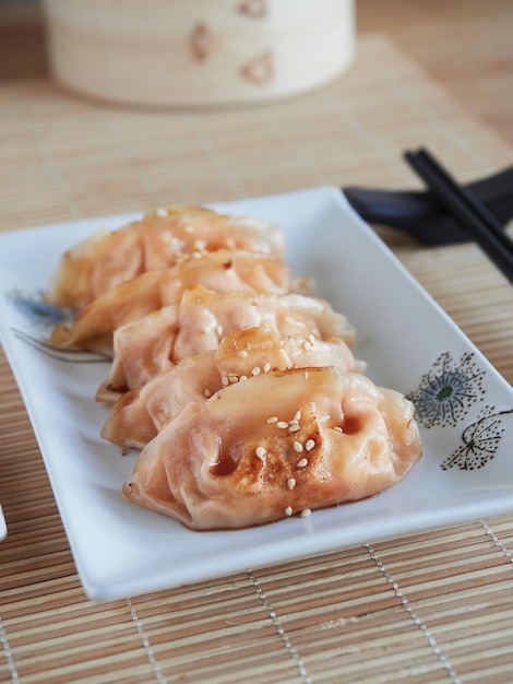 Close up view of fried gyozas with sesame seeds on top