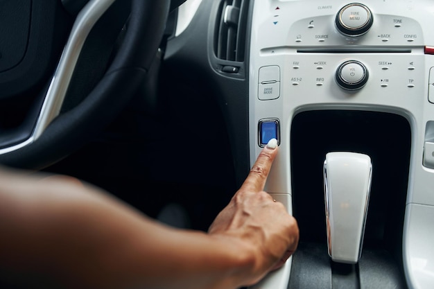 Close up view of front control panel woman in casual clothes is sitting in her automobile at daytime