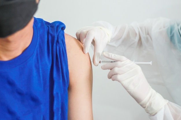 코로나 바이러스 전염병 동안 팔에 백신 주사를 맞는 모습을 가까이서 보세요. 의료 마스크에 환자입니다. 코로나19 또는 코로나바이러스 백신