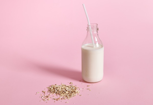 Close-up view of glass bottle with milk and oat flakes