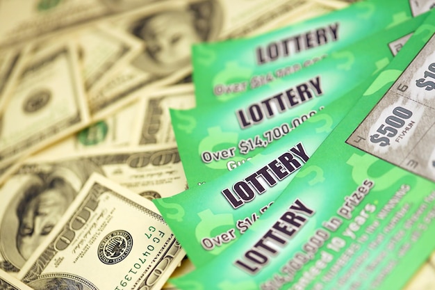 Close up view of green lottery scratch cards and us dollar bills Many used fake instant lottery tickets with gambling results Gambling addiction