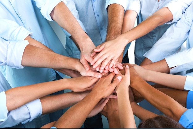 Close-up view of group of people stacking hands