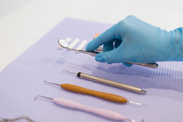 Close up view of hand of the dentist takes a mirror Many of dental instruments