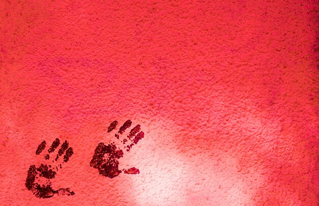 Photo close-up view of handprints on red wall