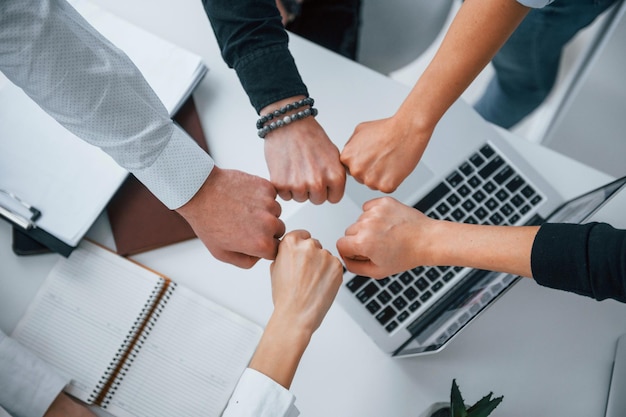 Close up view of hands of business people that celebrating success in the office