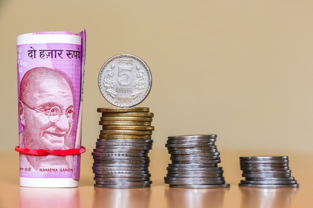 Close up view of indian rupees. Banknotes and stacked coins.