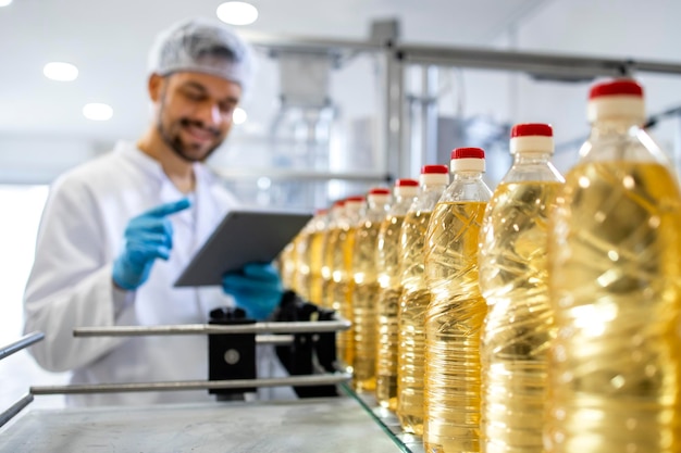 Close up view of industrial vegetable oil production and bottles filled with sunflower oil